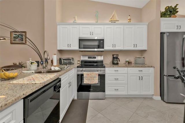 kitchen with sink, white cabinetry, stainless steel appliances, lofted ceiling, and light stone counters