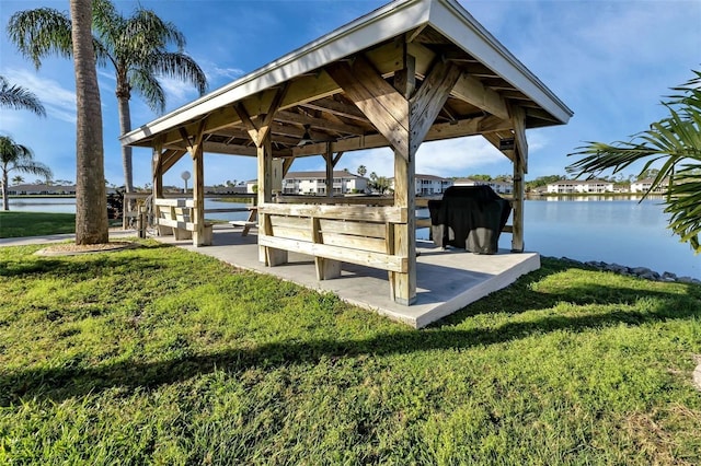 view of dock featuring a water view, a gazebo, and a lawn