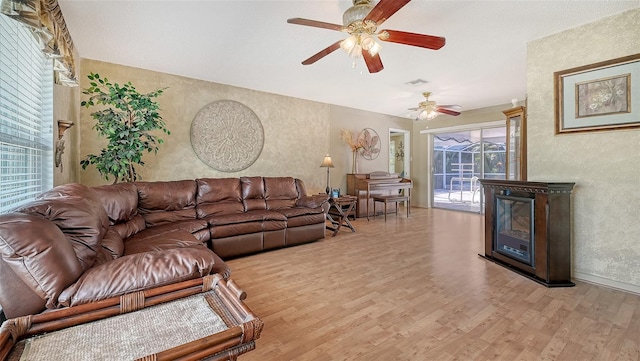 living room with light hardwood / wood-style floors and ceiling fan