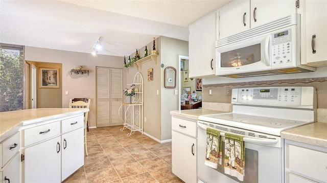 kitchen featuring white appliances, a textured ceiling, light tile patterned flooring, and white cabinets