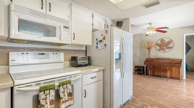 kitchen featuring white cabinets, a textured ceiling, ceiling fan, light wood-type flooring, and white appliances