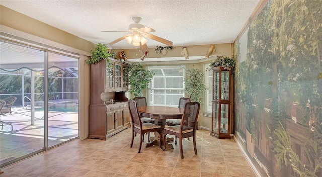 dining room featuring a wealth of natural light, a textured ceiling, and ceiling fan