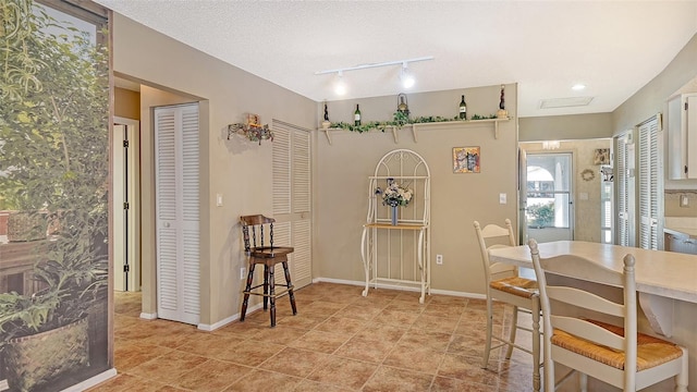 tiled dining area featuring a textured ceiling