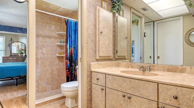 bathroom featuring hardwood / wood-style flooring, a shower with shower curtain, a textured ceiling, vanity, and toilet