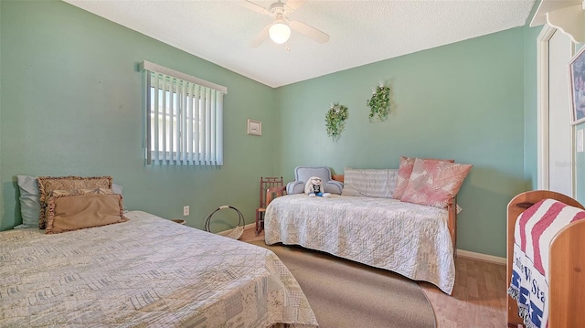 bedroom featuring a textured ceiling, wood-type flooring, and ceiling fan