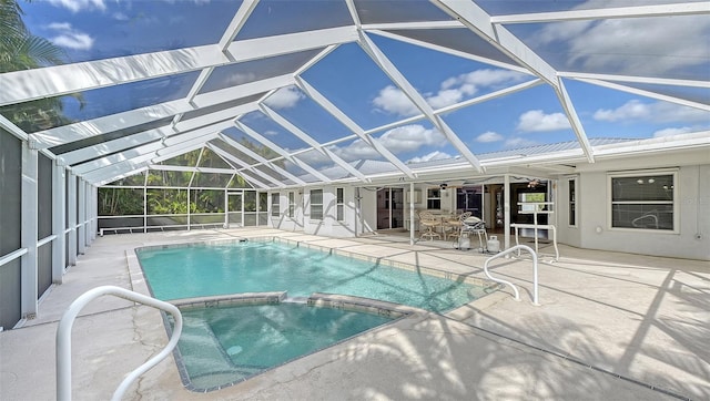 view of swimming pool featuring an in ground hot tub, glass enclosure, and a patio area