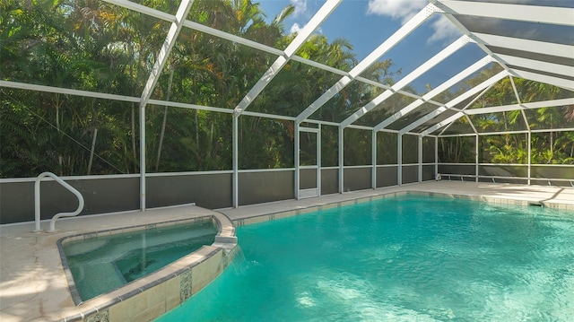 view of pool with a patio area, glass enclosure, and an in ground hot tub