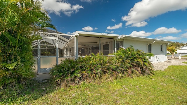 back of house featuring a yard and a lanai