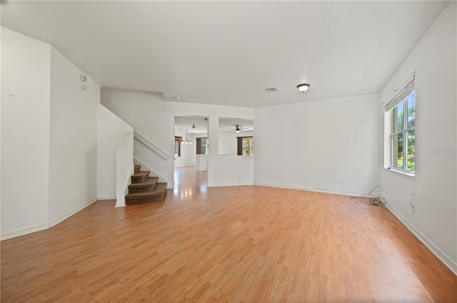 unfurnished living room featuring ceiling fan and light wood-type flooring