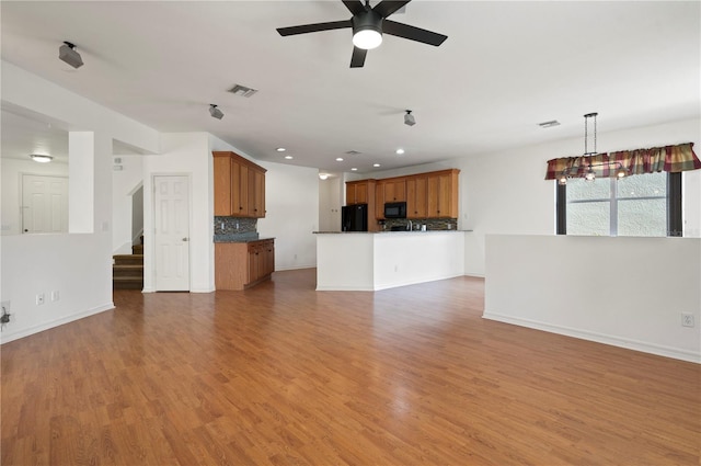 unfurnished living room with ceiling fan and hardwood / wood-style flooring