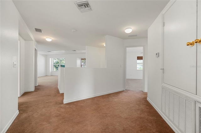 hallway featuring light colored carpet