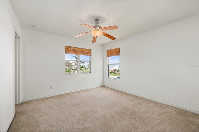 carpeted spare room featuring ceiling fan