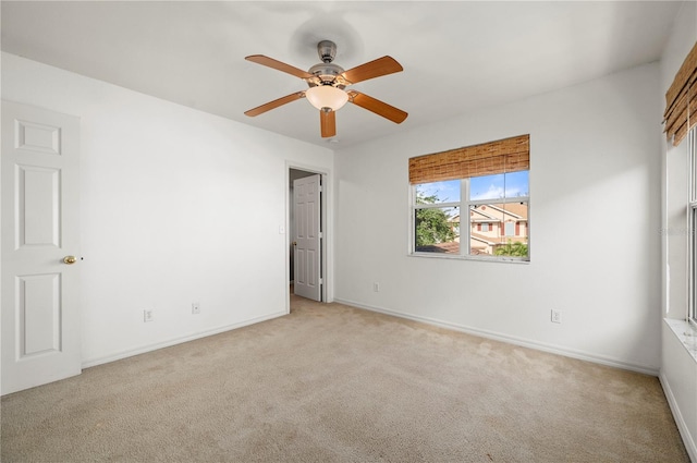 spare room featuring light colored carpet and ceiling fan