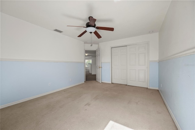 unfurnished bedroom with light carpet, a closet, and ceiling fan