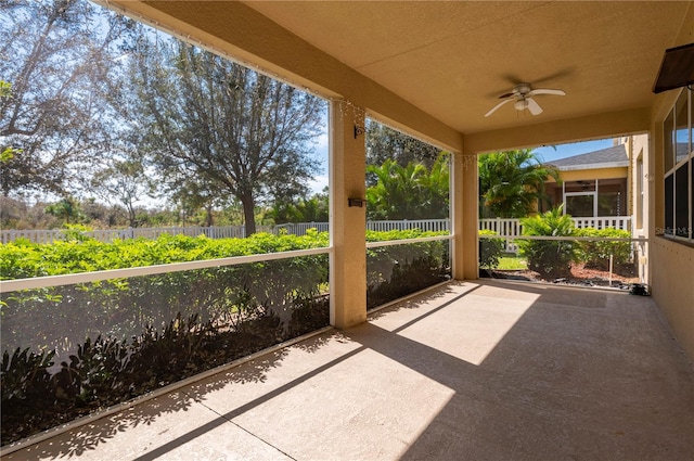 unfurnished sunroom with ceiling fan