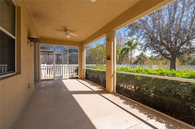 unfurnished sunroom with ceiling fan