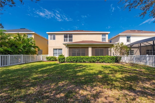 rear view of property featuring a yard and a lanai