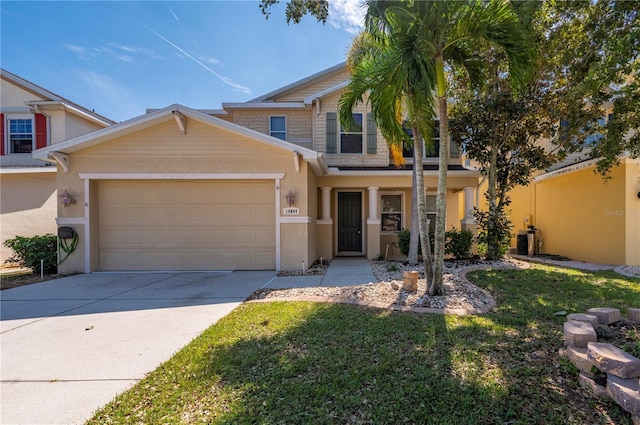 view of front of house featuring a front yard, concrete driveway, an attached garage, and stucco siding