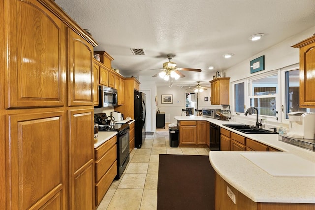 kitchen featuring sink, black appliances, kitchen peninsula, and a textured ceiling