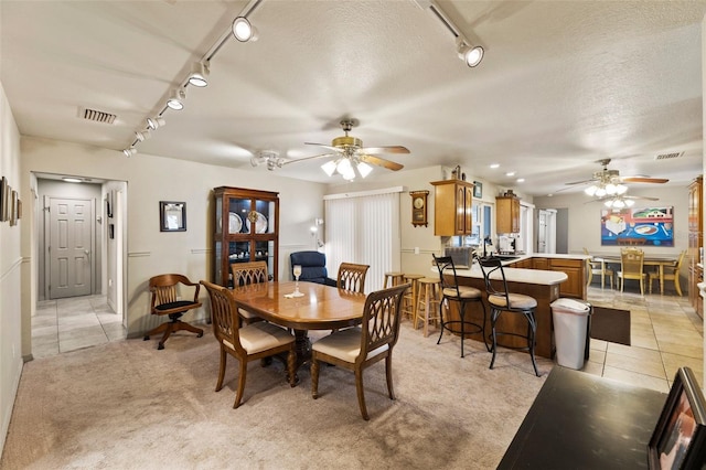 tiled dining room featuring ceiling fan and a textured ceiling