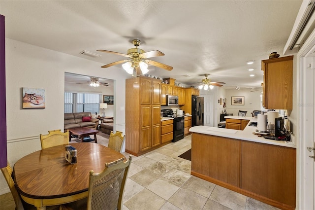 kitchen with black appliances, a textured ceiling, and kitchen peninsula