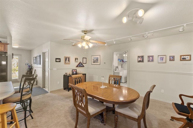 carpeted dining area featuring ceiling fan, a textured ceiling, washer / clothes dryer, and track lighting