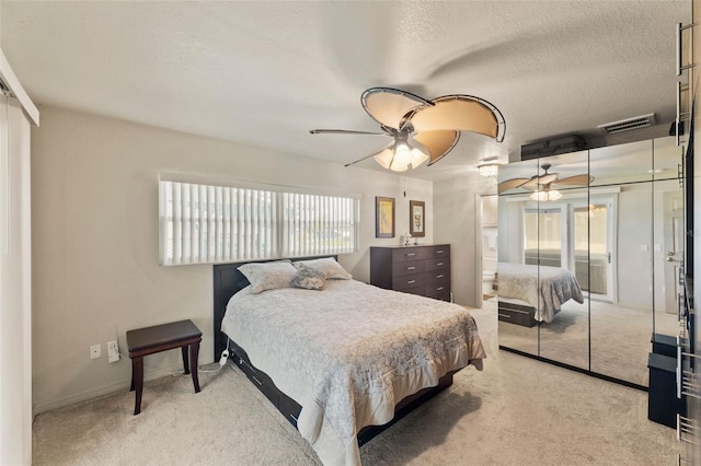 carpeted bedroom with a textured ceiling and ceiling fan