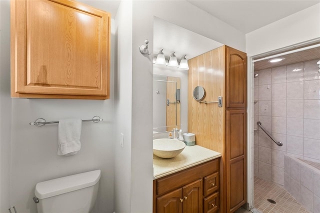 bathroom with vanity, a tile shower, and toilet