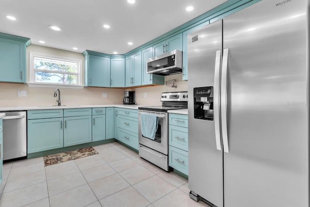 kitchen with sink, light tile patterned floors, and appliances with stainless steel finishes