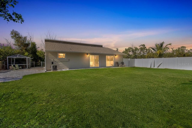 back house at dusk with a yard