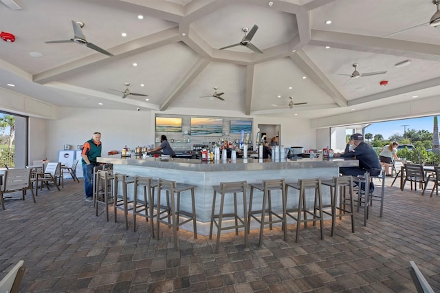 bar with a wealth of natural light, beam ceiling, and high vaulted ceiling