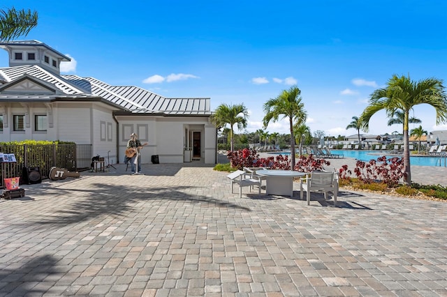 exterior space featuring a patio, a swimming pool, and a water view