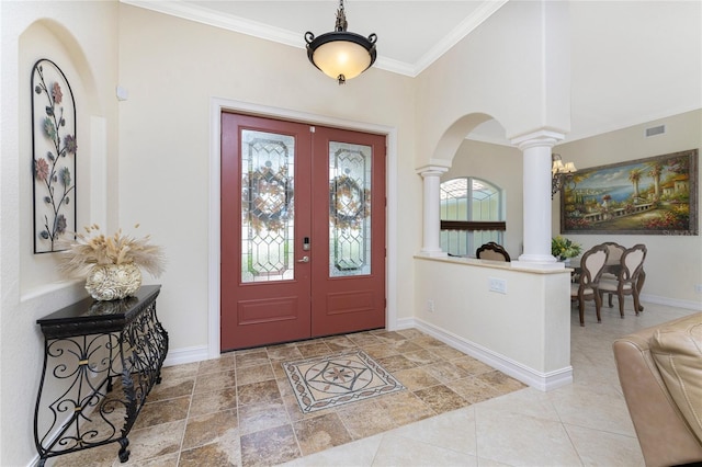 foyer entrance with decorative columns, french doors, and ornamental molding