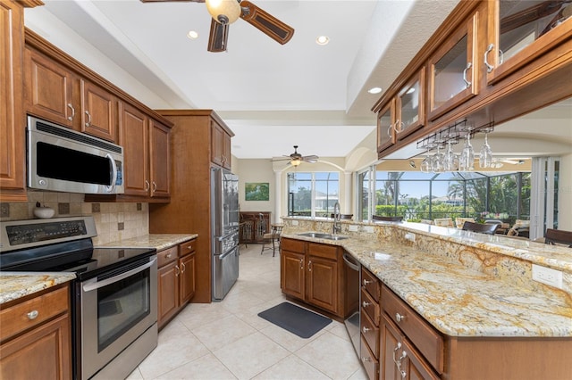 kitchen featuring light stone countertops, plenty of natural light, sink, and appliances with stainless steel finishes