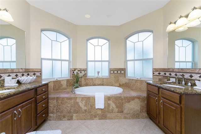 bathroom featuring vanity, a relaxing tiled tub, tile patterned flooring, and a healthy amount of sunlight