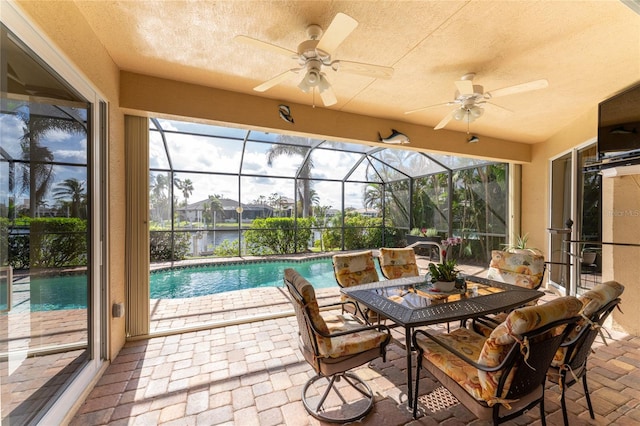 sunroom with ceiling fan, a water view, and a healthy amount of sunlight