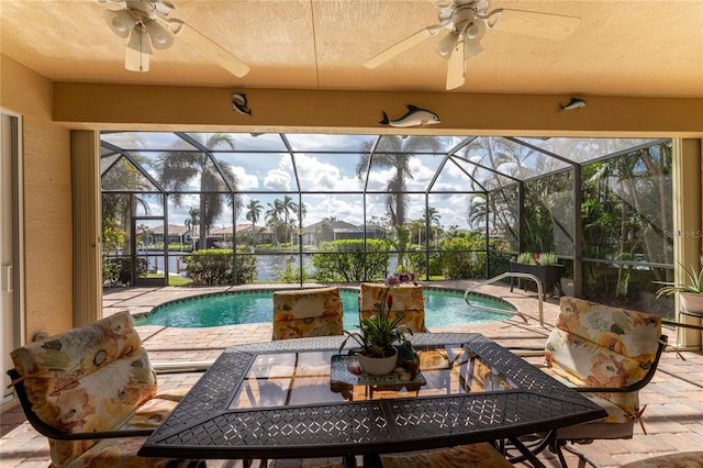 view of swimming pool featuring glass enclosure and a patio