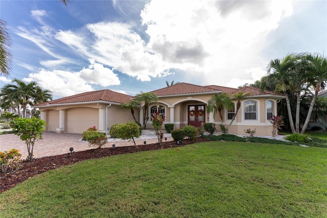 mediterranean / spanish home featuring french doors, a garage, and a front lawn