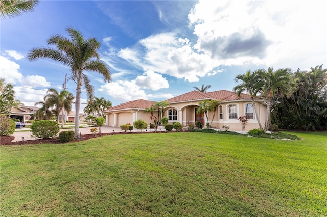 mediterranean / spanish house featuring a front lawn and a garage