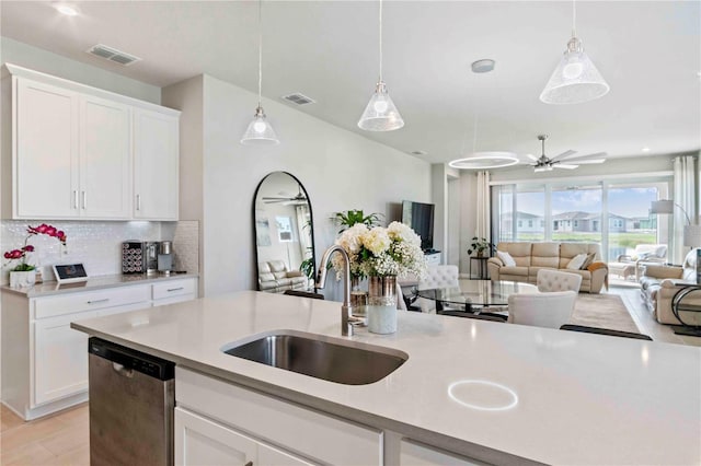 kitchen with sink, tasteful backsplash, decorative light fixtures, dishwasher, and white cabinets