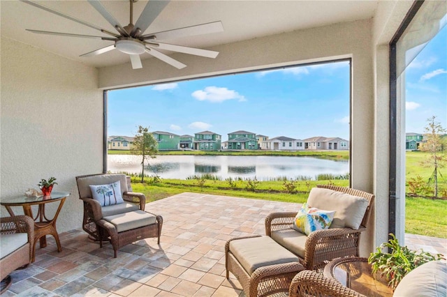 sunroom / solarium with a water view, ceiling fan, and plenty of natural light