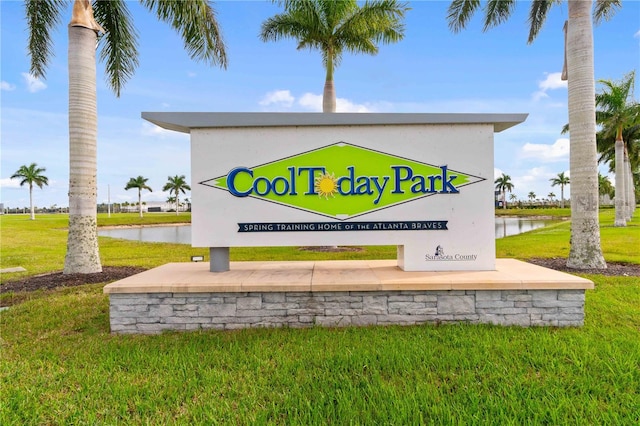 community / neighborhood sign with a water view and a yard