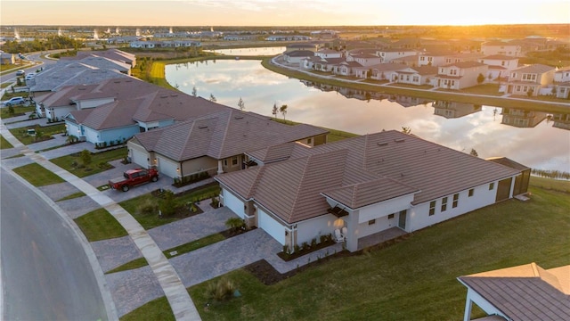 aerial view at dusk featuring a water view