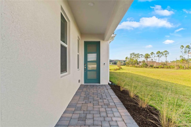 entrance to property featuring a lawn