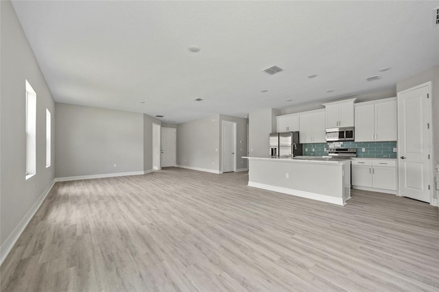 2404 Hanford Ln, North Port, FL 34288 - unfurnished living room with visible vents, a sink, baseboards, and light wood-type flooring