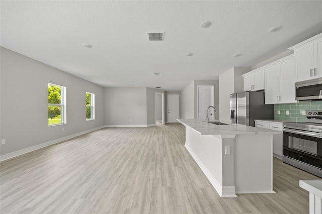 2404 Hanford Ln, North Port, FL 34288 - kitchen with visible vents, an island with sink, light wood-type flooring, a sink, and appliances with stainless steel finishes
