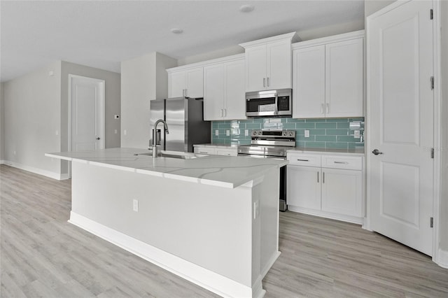 2404 Hanford Ln, North Port, FL 34288 - kitchen with white cabinetry, a kitchen island with sink, and stainless steel appliances