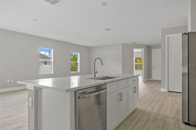 2404 Hanford Ln, North Port, FL 34288 - kitchen featuring stainless steel appliances, white cabinetry, a sink, and light wood-style flooring