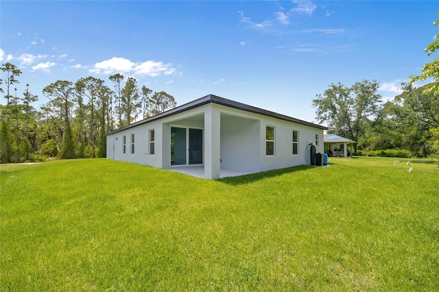 2404 Hanford Ln, North Port, FL 34288 - back of house featuring a yard, a patio, and stucco siding