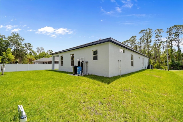 2404 Hanford Ln, North Port, FL 34288 - view of side of home featuring central air condition unit, stucco siding, a yard, and fence